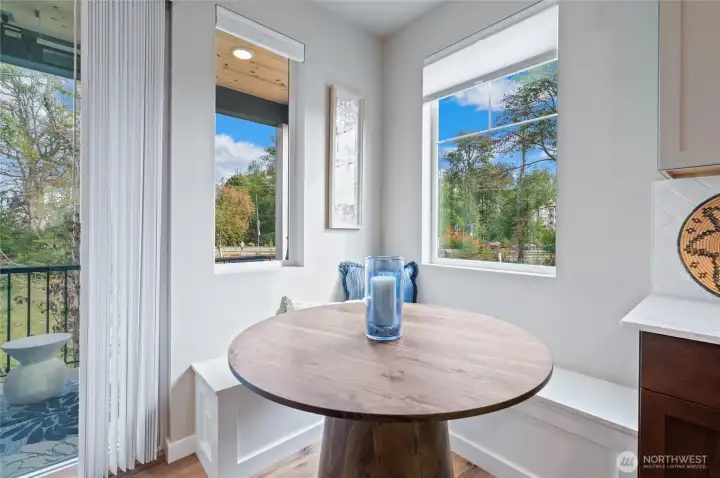 Built in seating bench in the eating area with extra windows for the corner unit home.   Photo is of community model home and same plan.