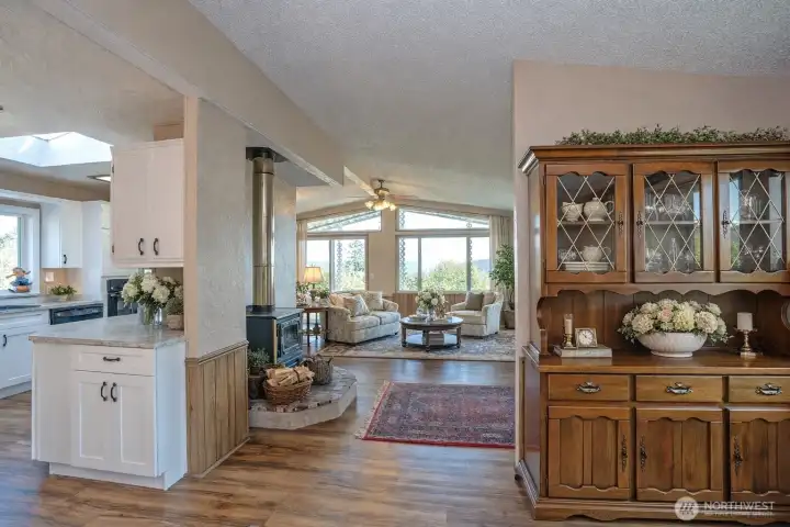 Open sightlines from the dining area to the living and kitchen, featuring vaulted ceilings and a bright, airy feel