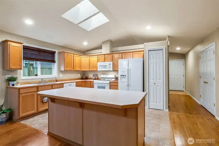 Spacious kitchen with iSland, gas range and skylights.