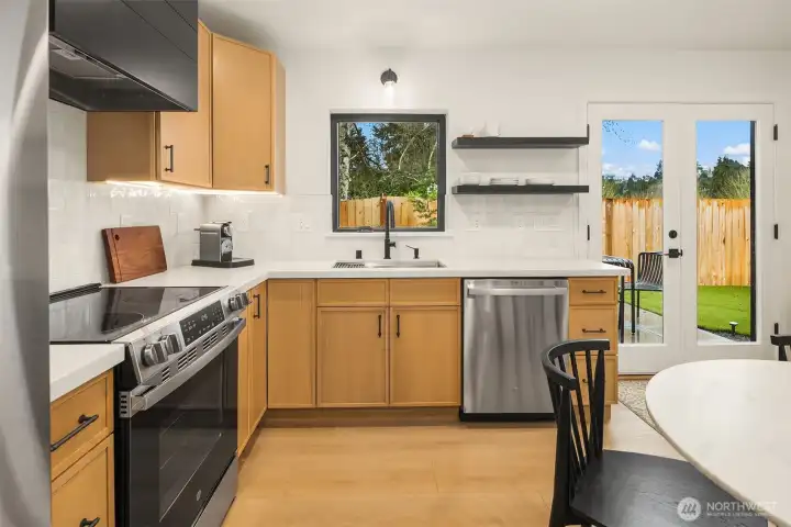 . French doors open to a warm, sun-drenched south-facing patio and fully fenced private yard with low-maintenance turf and curated garden spaces. A convenient powder room and direct access to the spacious garage complete this level.
