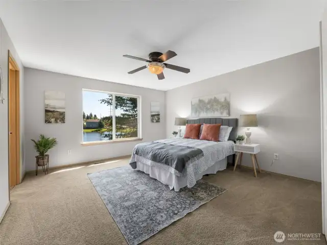 As you head upstairs you find the generous primary suite. And there's an amazing view right out that window to the backyard, lake and Mountain.