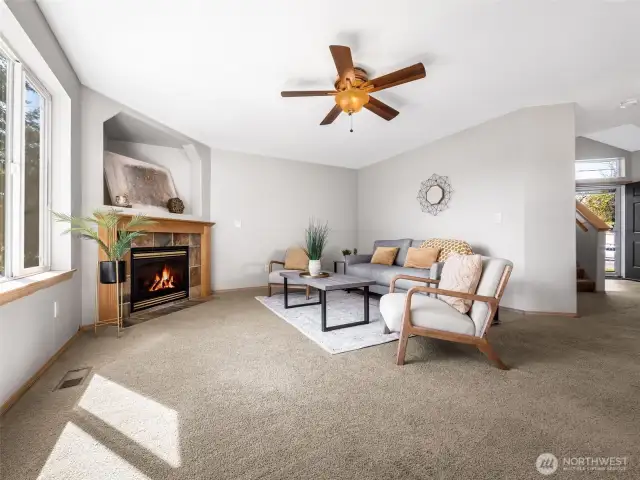 Here's one view of the living room with fireplace and ceiling fan a peek at the entry and stairs on the far right of the photo.