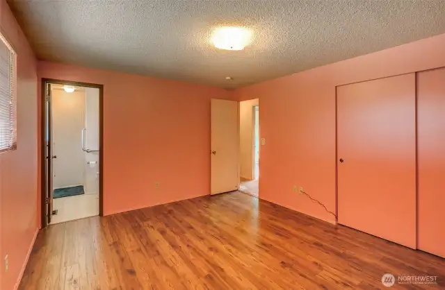 Primary Bedroom with 3/4 bath wood-like flooring.