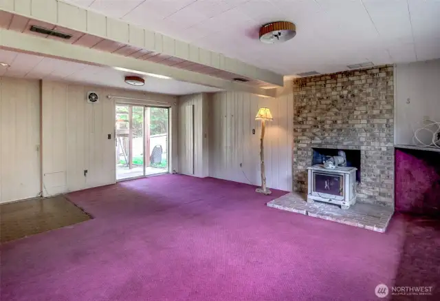 Large Family Rm on lower level w/2nd fireplace & an insert as well.  Electrical Panel is in closet to the left of the lamp by sliding doors.  There appears to be vinyl floor covering under this carpet.