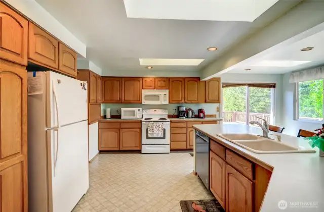 Large Open kitchen with eating at Island.  Sliders to expansive wood deck.