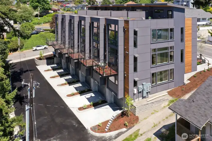 View of the back with parking garage, small decks off the main level.