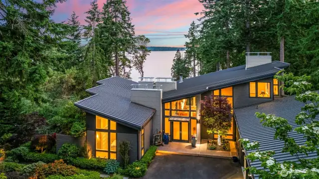 Bold rooflines, walls of glass, and intentional design define this elevated modern home overlooking the Sound. Perched above the shoreline, it blends structural elegance with the serenity of its Fox Island setting.
