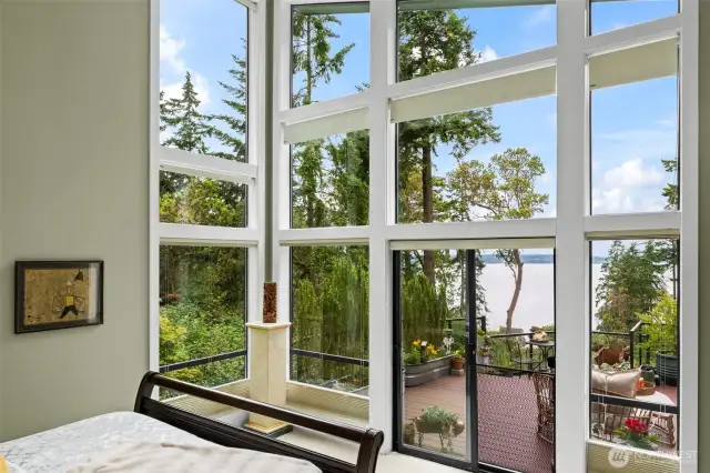 Simply awe inspiring!  This wall of glass captures private panoramic views and floods the primary suite with natural light—blurring the lines between indoors and nature.