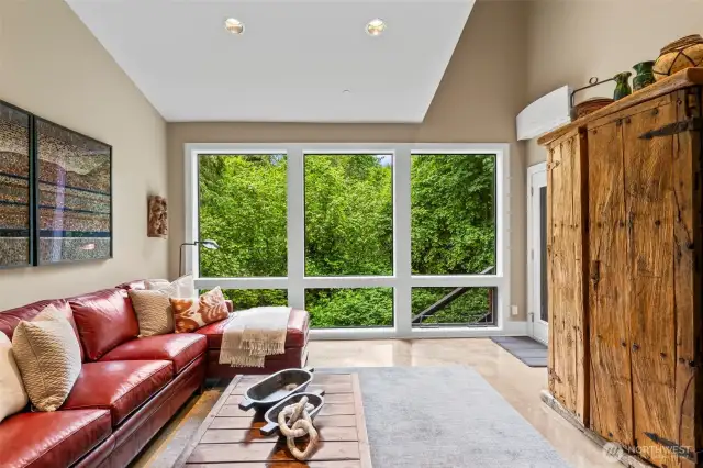 Charming main-level den or office with French doors, striking natural views, and its own private exit to the side deck—ideal for work-from-home focus or quiet reading retreat.