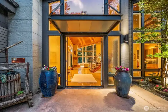 Welcome!  Step inside and experience the soul of this home—where architecture and artistry meet. This inviting entry with oversized glass doors sets the tone for a space defined by light, scale, and connection to the surrounding landscape.