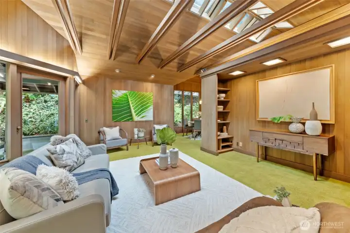 Exposed beams and skylights illuminate the space with natural light, while custom built-in shelving—around every corner showcases thoughtfully designed details.