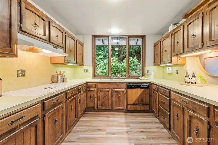 Expansive cabinetry lines this beautiful kitchen, with every detail designed for convenience and a charming window nook that adds light and character.