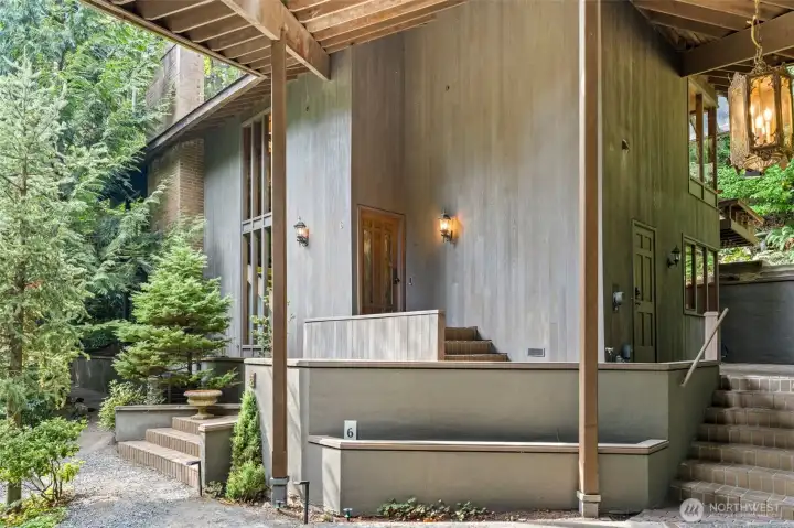 A distinguished entry framed by lush landscaping and elegant lantern lighting, creating a warm welcome that sets the stage for the home’s enduring sophistication.