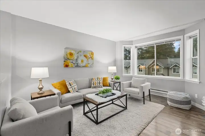 Beautiful laminate flooring extends through the main living areas, complemented by expansive picture windows that bathe the interior in warm, natural light.