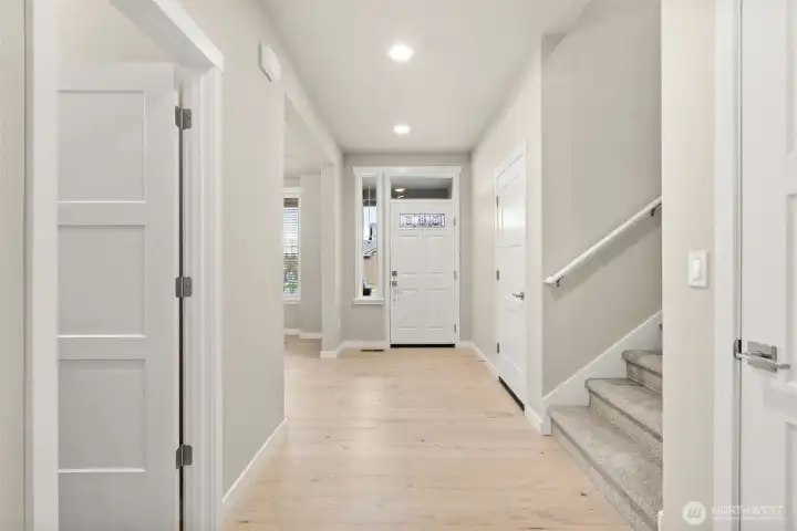 Welcome home! Open and inviting entry way. The front door with transom window above, allowing natural light to stream in and brighten the space.