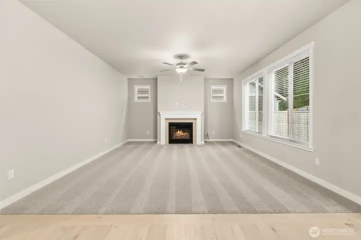 Spacious and inviting great room with a clean, modern design and gas fireplace including a ceiling fan.