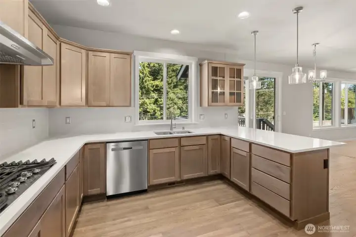 Kitchen opens into nook and a spacious living area with large windows creating a seamless flow ideal for both everyday living and entertaining.