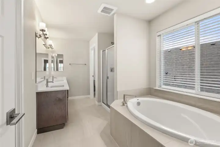 Primary bathroom- 5-piece. Soaking tub with tile surround.