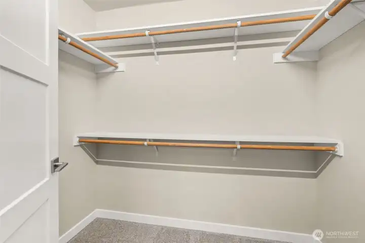 Primary bedroom features a walk-in closet with solid shelving.