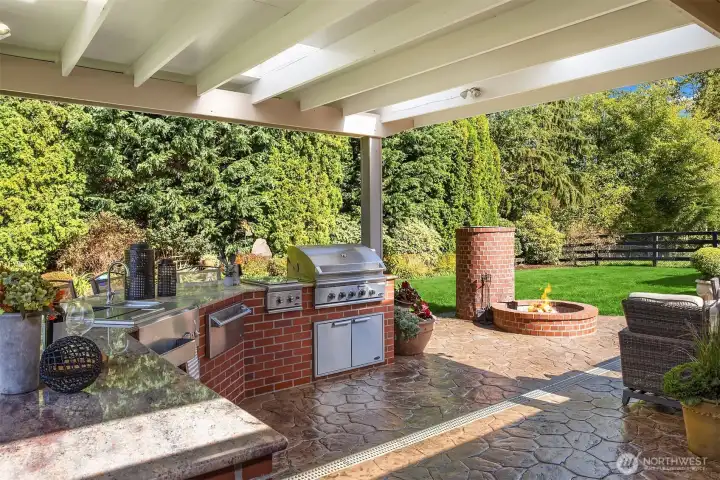 Covered outdoor living with grand scale custom-built outdoor kitchen