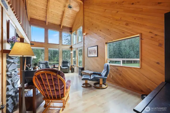 Main entry opens to soaring vaulted ceilings, with warm red cedar, Pergo flooring, and hemlock accents creating a cozy, inviting feel throughout.