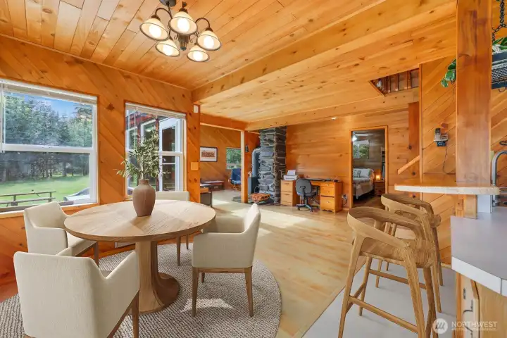 Your dining room with eat in space at the kitchen bar. Adjacent to the dining room, this flexible space works beautifully to place a hutch, desk, coffee bar, or utilize as a sitting area. The primary bedroom is ahead and laundry to the right. Virtually staged to showcase possibilities.