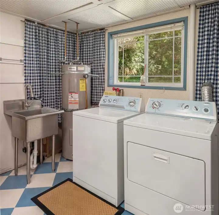 Laundry area is on ground level with cheery vinyl tile floor and free-standing sink.