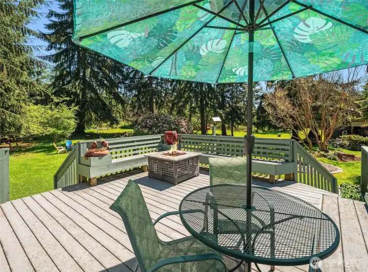 Lower level deck has two stairways down into the grounds and lots of built-in seating. This space is very inviting!