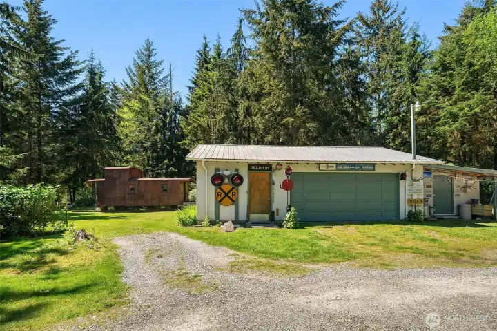 Two car garage with attached shop and covered outdoor work area. Caboose is included!