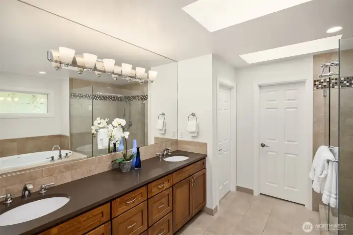 The primary bathroom has been fully updated. The door at the end is a large walk-in closet
