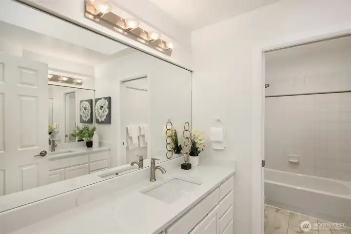 The family bathroom has been updated with luxury vinyl tile, new countertops, sinks and hardware. This bathroom is brilliantly designed with two vanities (one on either side), both with oodles of countertop space. The bath and WC can be closed off for privacy