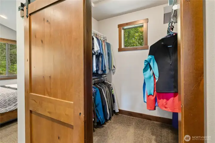 A charming barn-style door opens to the spacious walk-in closet, adding rustic character and style to the suite.