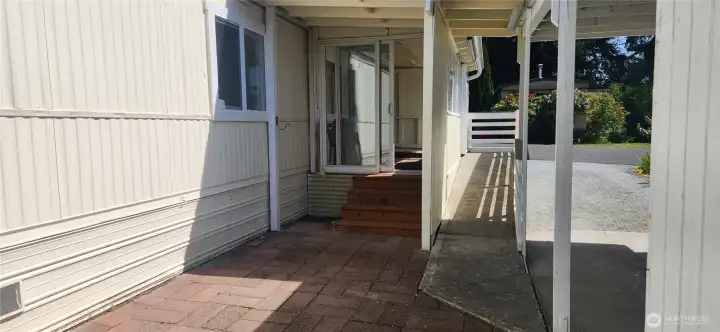 Carport to your right with a great view of the ramp that leads to your front door. The patio is terrific for private outdoor enjoyment or step up to the enclosed front porch with windows and sliding glass door. Carport to your right with a great view of the ramp that leads to your front door. The patio is terrific for private outdoor enjoyment or step up to the enclosed front porch with windows and sliding glass door.