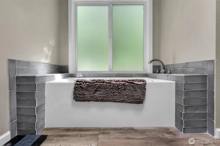 Primary bath has an alcove with a soaking tub.