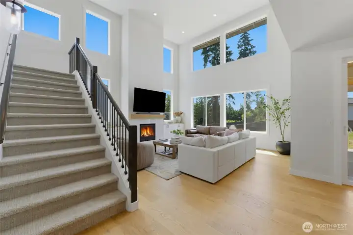 The great room's soaring ceilings and oversized windows flood the space with natural light, anchored by a cozy gas fireplace. The great room's soaring ceilings and oversized windows flood the space with natural light, anchored by a cozy gas fireplace.
