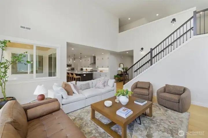 The great room's soaring ceilings create an airy, open feel, flowing seamlessly into the kitchen and up the dramatic staircase. The great room's soaring ceilings create an airy, open feel, flowing seamlessly into the kitchen and up the dramatic staircase.