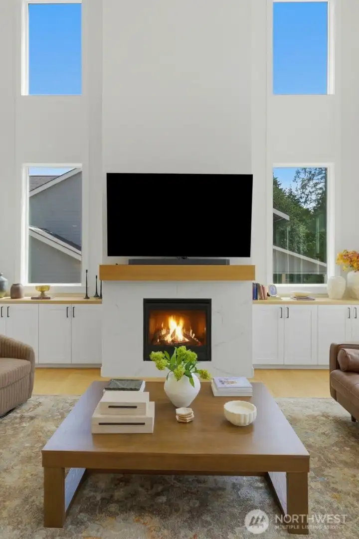 The great room's striking floor-to-ceiling fireplace, framed by oversized windows and matching built-in cabinetry on either side. The great room's striking floor-to-ceiling fireplace, framed by oversized windows and matching built-in cabinetry on either side.