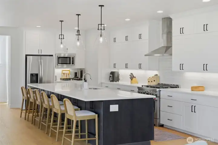 The chef's kitchen is the heart of this home: a 15-foot island, custom cabinetry extending to the ceiling, a stainless range with hood, and seating for the whole crew. The chef's kitchen is the heart of this home: a 15-foot island, custom cabinetry extending to the ceiling, a stainless range with hood, and seating for the whole crew.