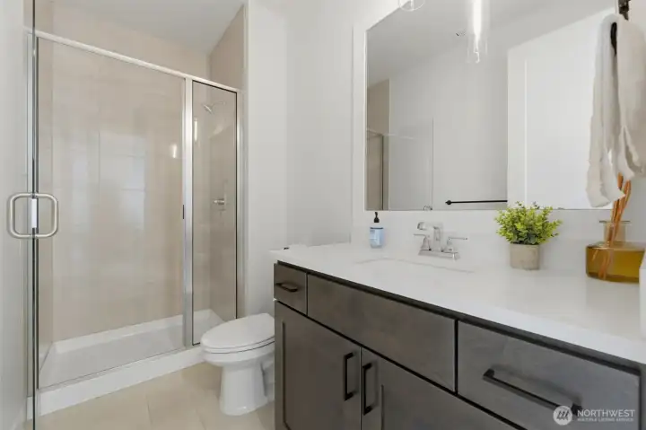 This ¾ bath, located just off the main-floor bedroom, features a walk-in shower and stylish dark-stained vanity — ideal for guests. This ¾ bath, located just off the main-floor bedroom, features a walk-in shower and stylish dark-stained vanity — ideal for guests.
