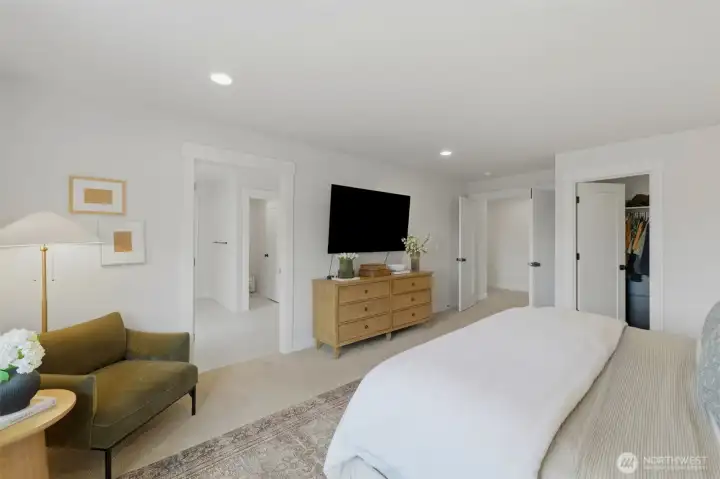 Spacious primary suite featuring a walk-in closet, en suite bath access, and room for a sitting area. Spacious primary suite featuring a walk-in closet, en suite bath access, and room for a sitting area.