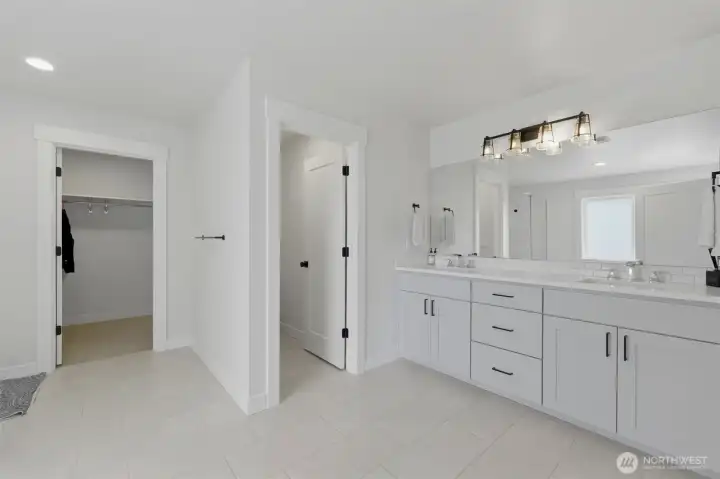 The primary suite's spa-like bath features a dual-sink vanity, separate water closet, and a generously sized walk-in closet just steps away. The primary suite's spa-like bath features a dual-sink vanity, separate water closet, and a generously sized walk-in closet just steps away.