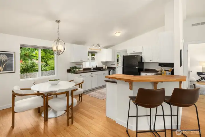The spacious kitchen with solid surface counters and wood cabinetry offers a custom wood breakfast counter. The spacious kitchen with solid surface counters and wood cabinetry offers a custom wood breakfast counter.