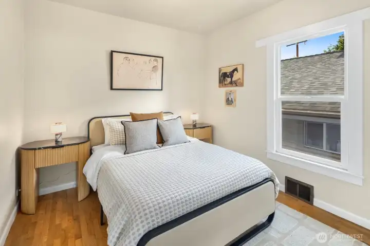 Comfortable and light-filled, this bedroom with beautifully refinished oak floors offers a peaceful retreat at the end of the day. High ceilings throughout this first floor are so lovely!