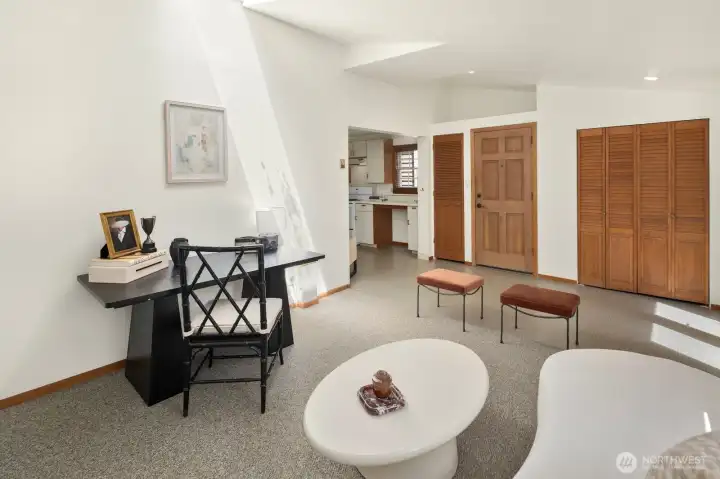 An open layout creates a seamless connection between the living area / dining space and kitchen. Door shown in this photo is unit's private front door entrance from north side of building.