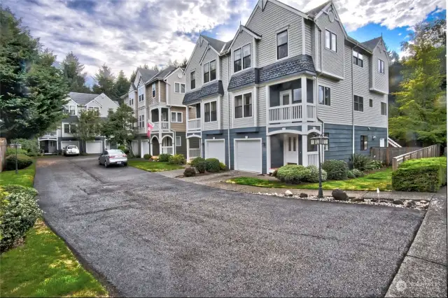 Front view of the complex , This is the end unit with a Tantum Two car garage.  Notice fenced yard for the unit with raised beds for the gardener.