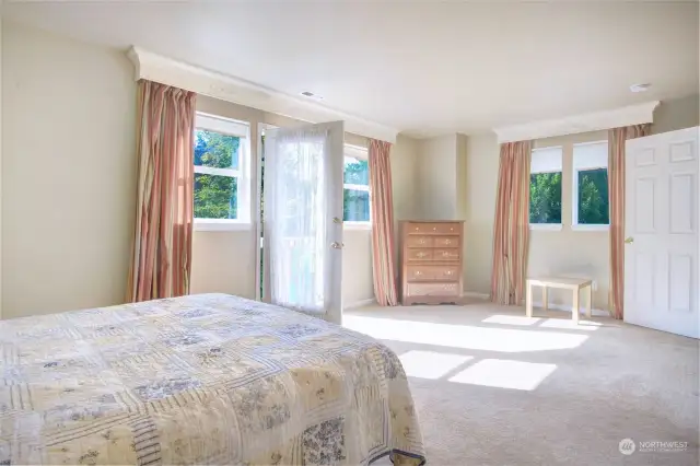 Another view of the primary bedroom showing there is room for a private sitting area if desired, and door to the deck.