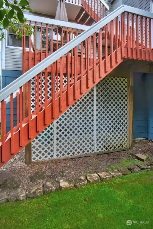 Picture of back of the home with the storage under the deck area screened off.