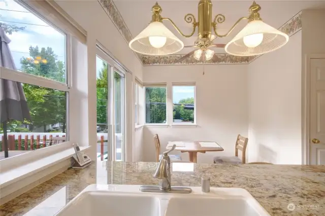 View of kitchen nook from the sink and breakfast bar area. Sliding glass doors to deck.