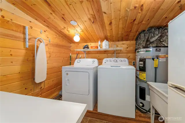 Practical Main Floor Utility Room    This utility room comes equipped with a washer, dryer, electric hot water tank, utility sink, and additional storage with a folding table for added convenience.
