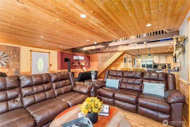 Cozy Main Floor Living Area    Relax in style with reclining sofas, a smart TV equipped for streaming, and charming tongue-and-groove wood accents that add warmth and character to this inviting space.